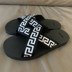 Black rubber Greca-motif crossover-strap sandals from VERSACE